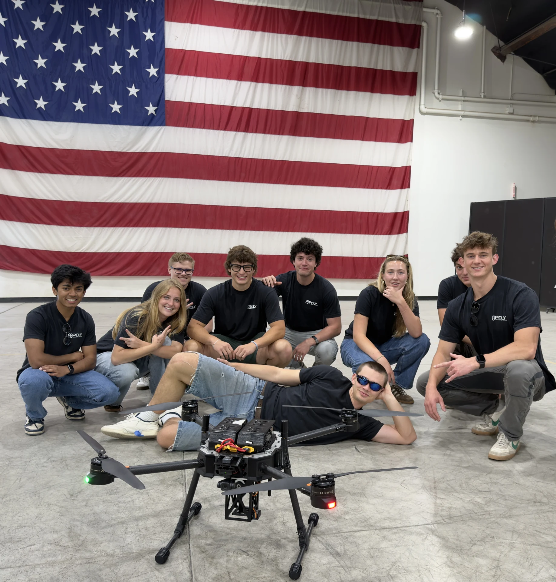 Osiris and the Cal Poly PolyUAS team at the 2026 competition. The completed aircraft and its underslung payload are visible in the foreground.
